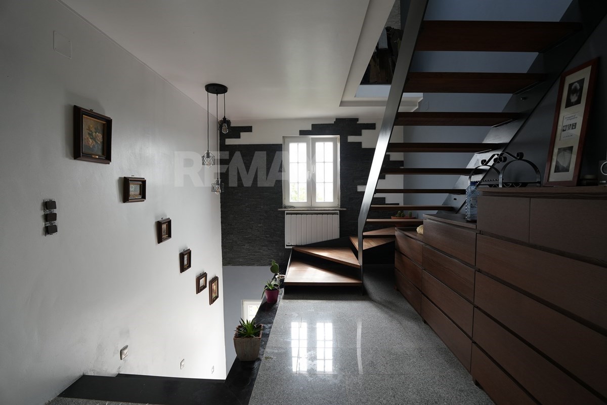 Indoor open wooden staircase with dark treads, pale structural sides, polished floor, wall pictures, plants, built-in cabinetry, and a window below.